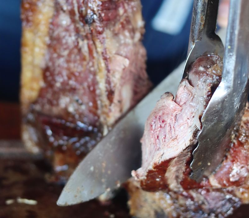 Un corte de asado recién hecho, cortado con cuchillo y pinza en Estancia Rio Mitre.
