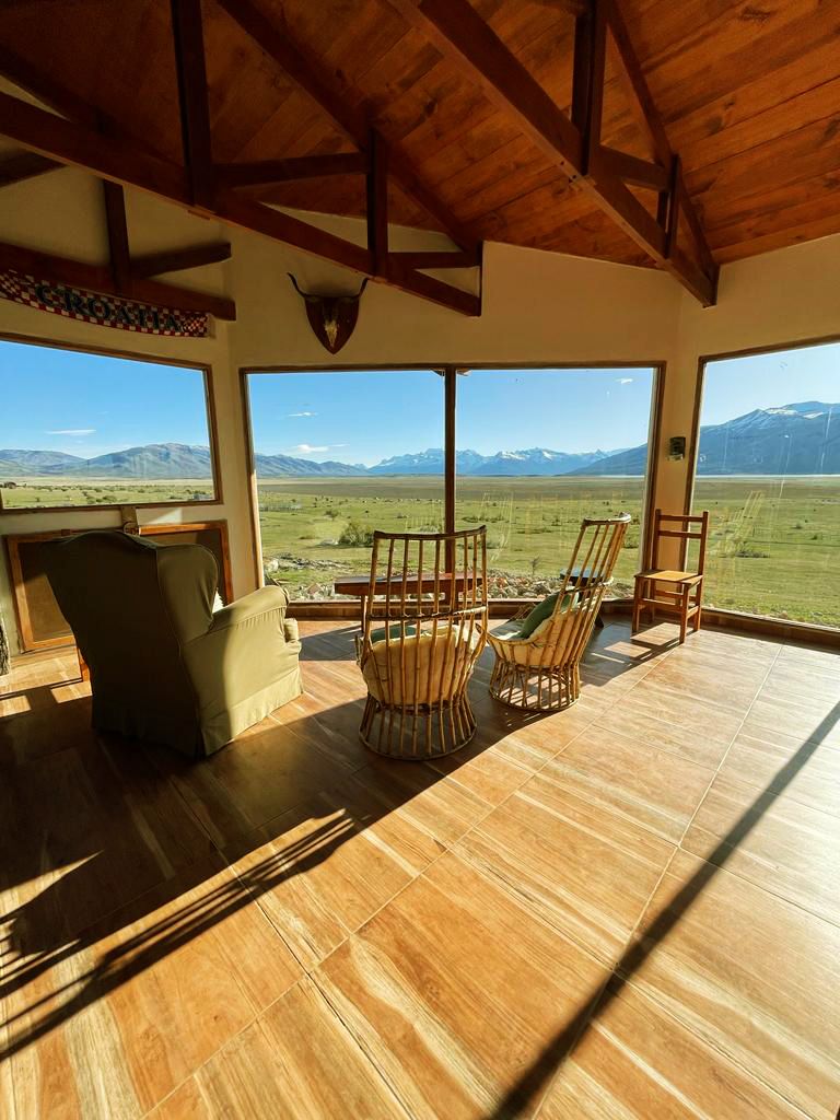 Salón de la estancia con ventanales hacia la estepa.